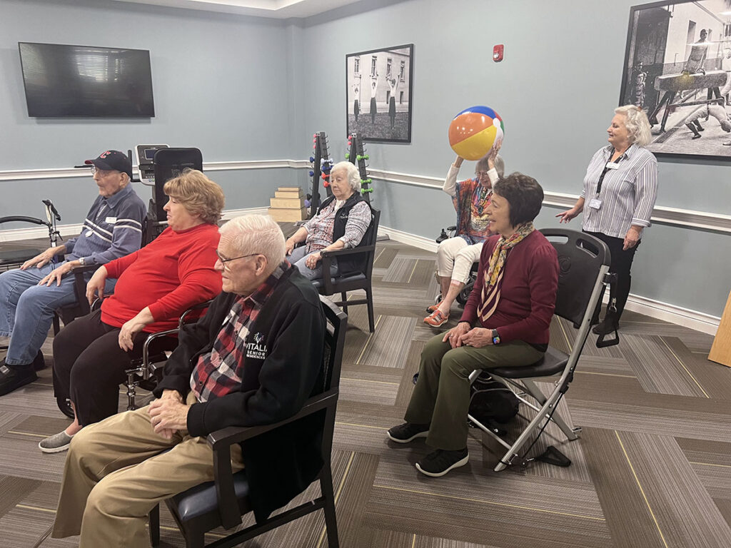 New employees and senior residents bond over a game of beachball chair volleyball, creating new connections and cherished memories. (right side of the room)