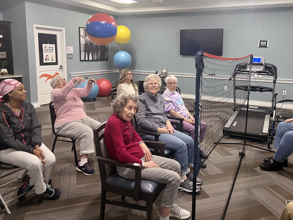 New employees and senior residents bond over a game of beachball chair volleyball, creating new connections and cherished memories. (left side of the room)