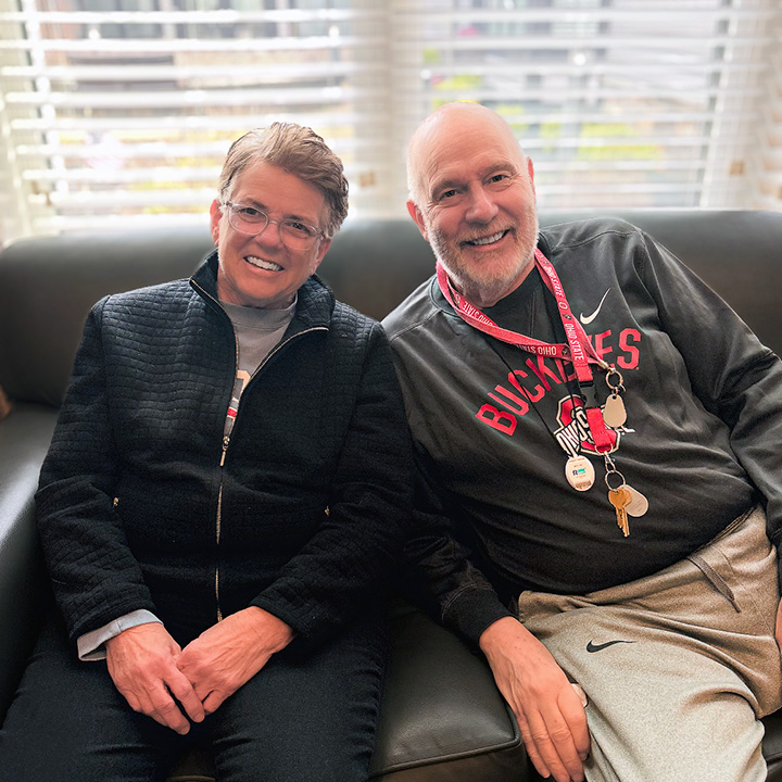 A woman and senior man smile in a comfortable seating area at Vitalia Stow.