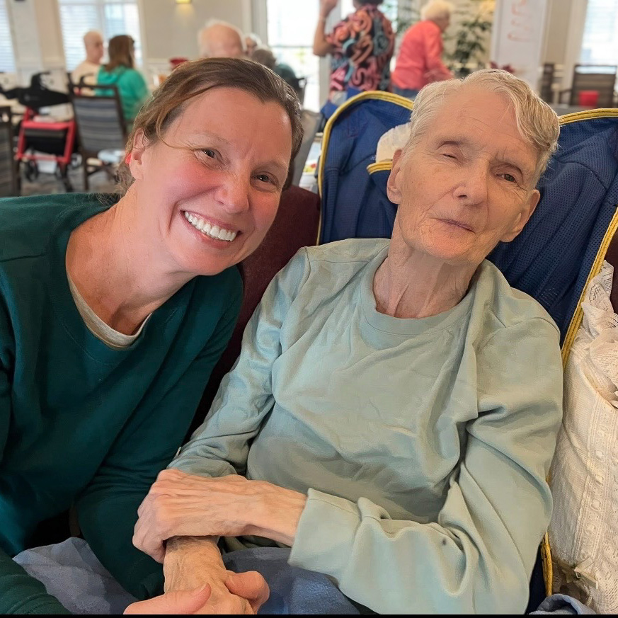 A senior resident and loved one smile during a relaxed moment.
