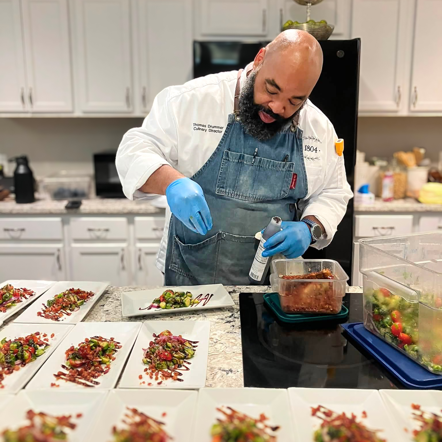 Thomas Drummer, the Culinary Director of 1804 seasons a series of freshly made salads at Vitalia Stow Senior Living. 
